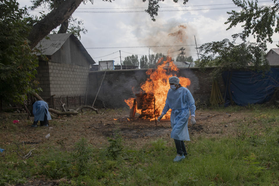 An Indian paramilitary soldier walks back after performing religious rituals during the cremation of his colleague who died of COVID-19, at a crematorium in Srinagar, Indian controlled Kashmir, Saturday, July 18, 2020. India crossed 1 million coronavirus cases on Friday, third only to the United States and Brazil, prompting concerns about its readiness to confront an inevitable surge that could overwhelm hospitals and test the country's feeble health care system. (AP Photo/Dar Yasin)