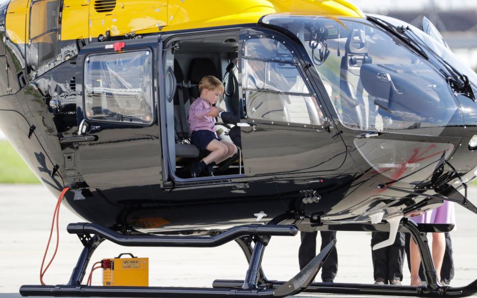 Prince George sits in a helicopter as he and his parents, the Duke of Cambridge and Duchess of Cambridge - Credit: CARSTEN KOALL/EPA