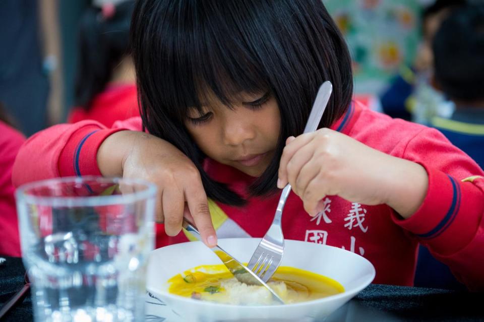 小女生優雅學習刀叉禮儀。