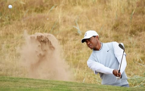 Tiger Woods of the United States plays out a bunker on the 1st hole while practicing during previews to the 147th Open Championship at Carnoustie - Credit: R&A via Getty Images