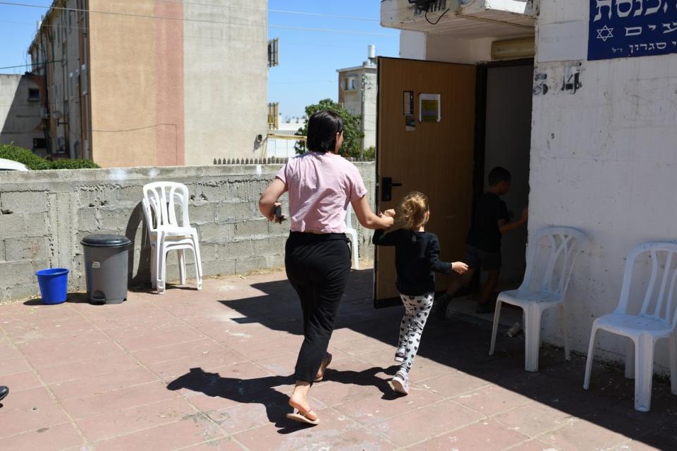 An Israeli woman and her daughter are running into a public bomb shelter, generally used as a synagogue, during a rocket barrage fired from the Gaza Strip on May 18, 2021, in the Southern city of Ashkelon. (Gili Yaari/NurPhoto via Getty Images)