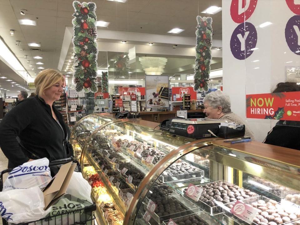 Judy Sellecchia of Philadelphia buys some candy from sales clerk Janice Mangini at the candy counter in the Boscov's store at Neshaminy Mall on Black Friday.