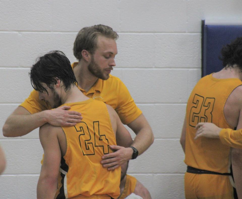Pellston coach Nate Meinke consoles senior Hale Dufresne (24) during the final stages of Wednesday's district clash against Mackinaw City.