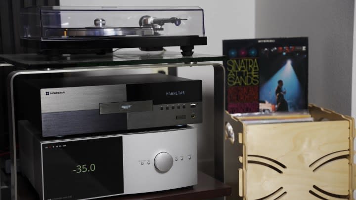 An AV gear rack with turntable, Mangetar receiver, and collection of vinyl records. 