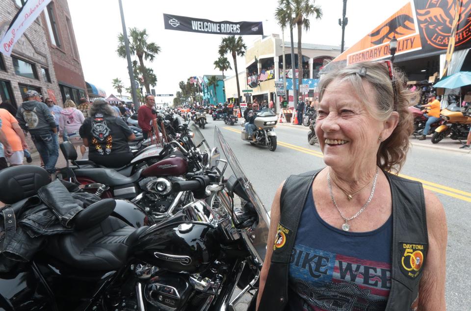 Biker Carolyn "Cricket" Lapins talks with passersby along Main Street during the 83rd Annual Bike Week in Daytona Beach. She has been riding her own motorcycle to the event every year, without fail, since 1987. "There are a lot more women riders now," she said.