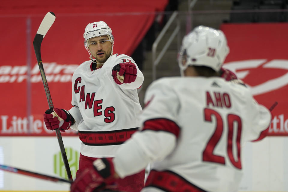 Carolina Hurricanes right wing Nino Niederreiter (21) celebrates his goal with Sebastian Aho (20) in the third period of an NHL hockey game against the Detroit Red Wings, Sunday, March 14, 2021, in Detroit. (AP Photo/Paul Sancya)