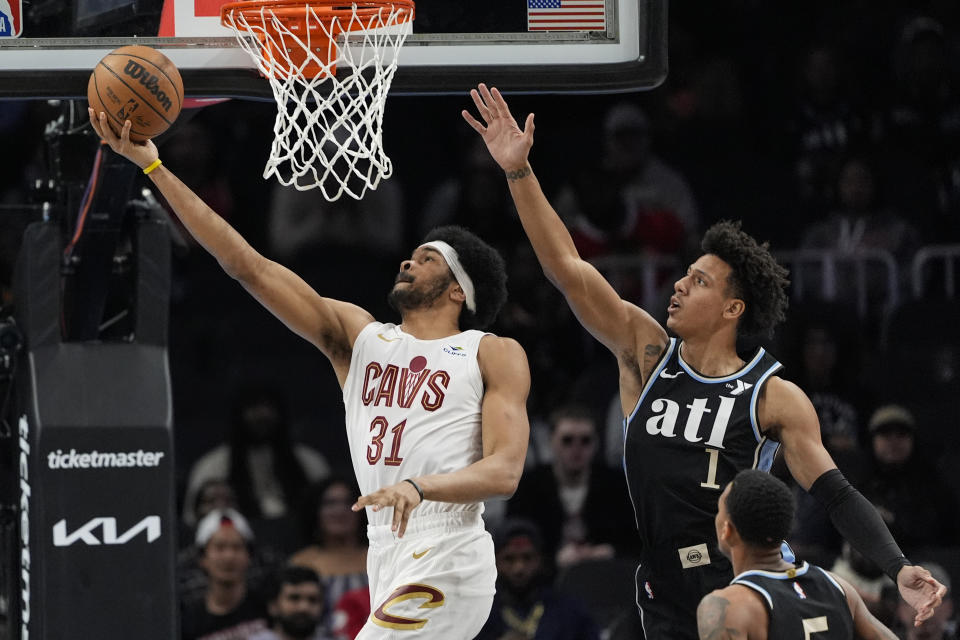 Cleveland Cavaliers center Jarrett Allen (31) scores as Atlanta Hawks forward Jalen Johnson (1) defends during the first half of an NBA basketball game Wednesday, March 6, 2024, in Atlanta. (AP Photo/John Bazemore)