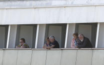 Passengers look out their balconies aboard the cruise ship Rotterdam as they wait to disembark at Port Everglades, Thursday, April 2, 2020, in Fort Lauderdale, Fla. A cruise ship that has been floating at sea with coronavirus patients aboard for two weeks after being turned away from South American ports was finally allowed to dock in Florida. The Zaandam and a sister ship sent to help it, the Rotterdam, were both given permission to disembark passengers at Port Everglades after days of negotiation with local officials who feared it would divert needed resources from a region that has seen a spike in virus cases. (AP Photo/Wilfredo Lee)