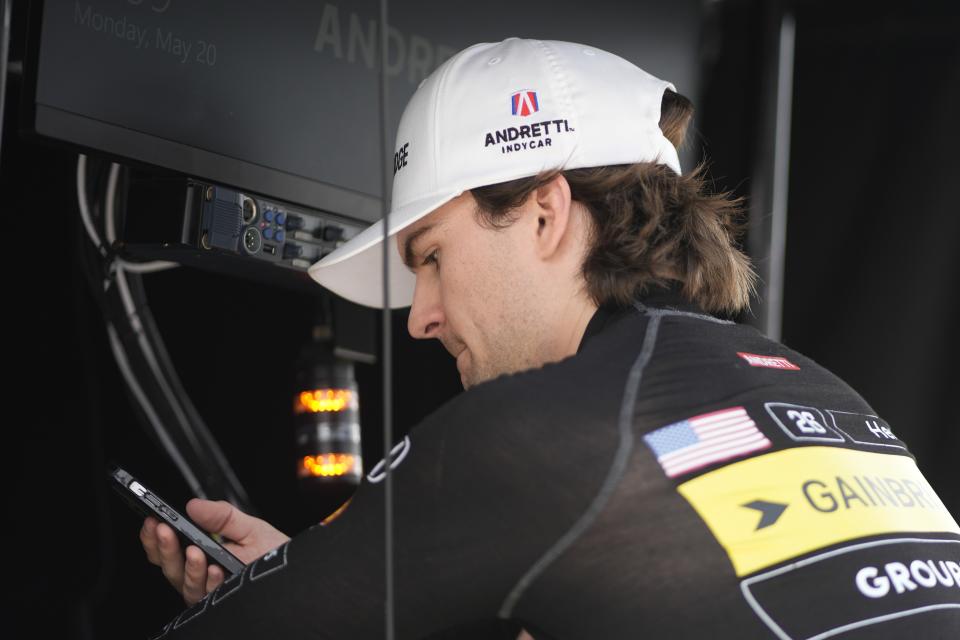 Colton Herta looks at his phone during a practice session for the Indianapolis 500 auto race at Indianapolis Motor Speedway, Monday, May 20, 2024, in Indianapolis. (AP Photo/Darron Cummings)