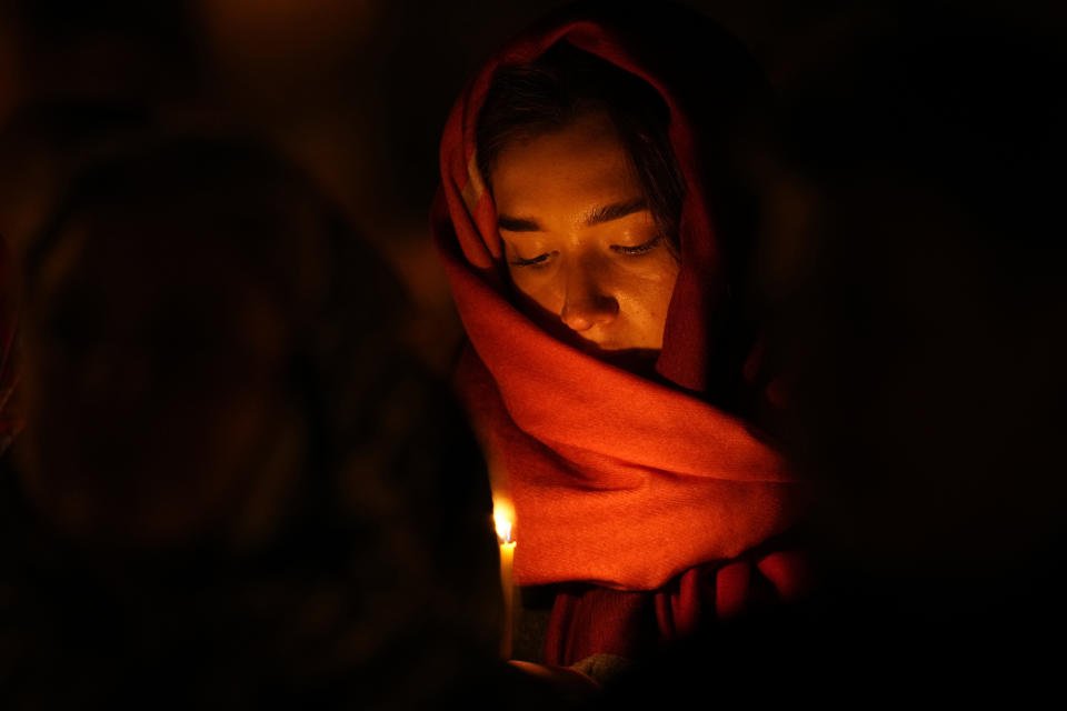 An Orthodox believer looks at her candle during Orthodox Easter midnight service at a church in St. Petersburg, Russia, Sunday, May 5, 2024. Eastern Orthodox churches observe the ancient Julian calendar and this year celebrate Orthodox Easter on May 5. (AP Photo/Dmitri Lovetsky)