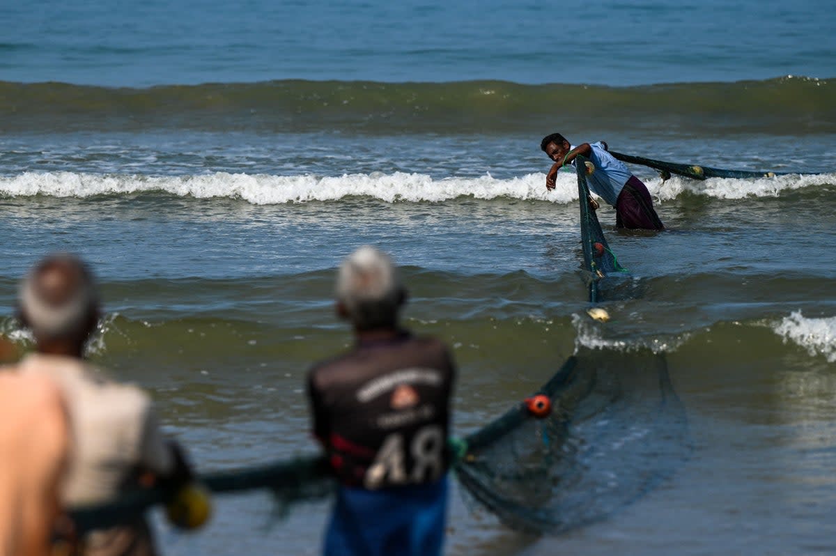 Fishermen pull a fishing net at a beach in Galle, Sri Lanka (AFP via Getty)