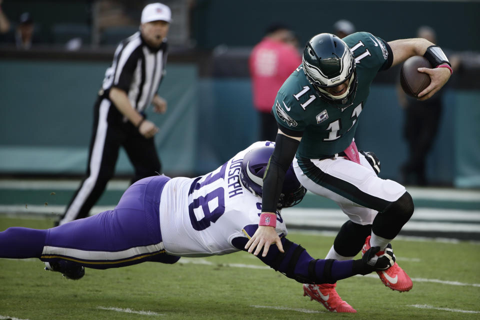 Philadelphia Eagles' Carson Wentz, right, tries to avoid Minnesota Vikings' Linval Joseph during the first half of an NFL football game, Sunday, Oct. 7, 2018, in Philadelphia. (AP Photo/Matt Rourke)