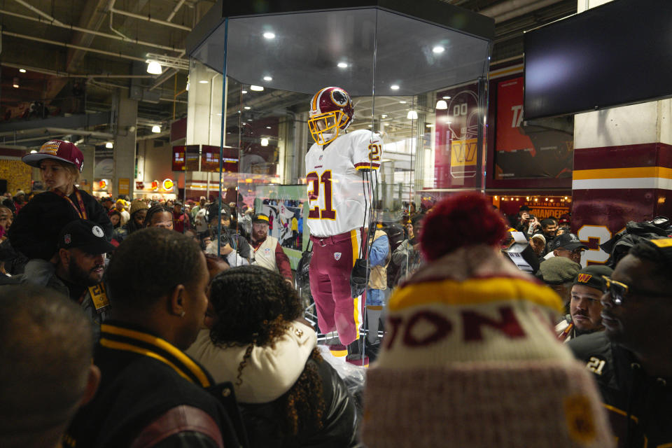 Fans attends the unveiling of the Sean Taylor Memorial, before the start of an NFL football game between the Atlanta Falcons and Washington Commanders, Sunday, Nov. 27, 2022, in Landover, Md. On the 15th anniversary of the death of Taylor, ever Commander player will wear a No. 21 decal on their helmet. (AP Photo/Jessica Rapfogel)