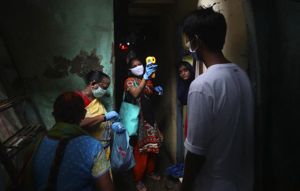 A health worker takes a person's temperature.