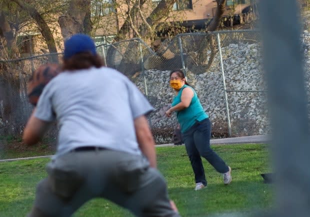 Two people play catch in a Centretown park on April 17, 2021, during the third wave of the COVID-19 pandemic. (Trevor Pritchard/CBC - image credit)