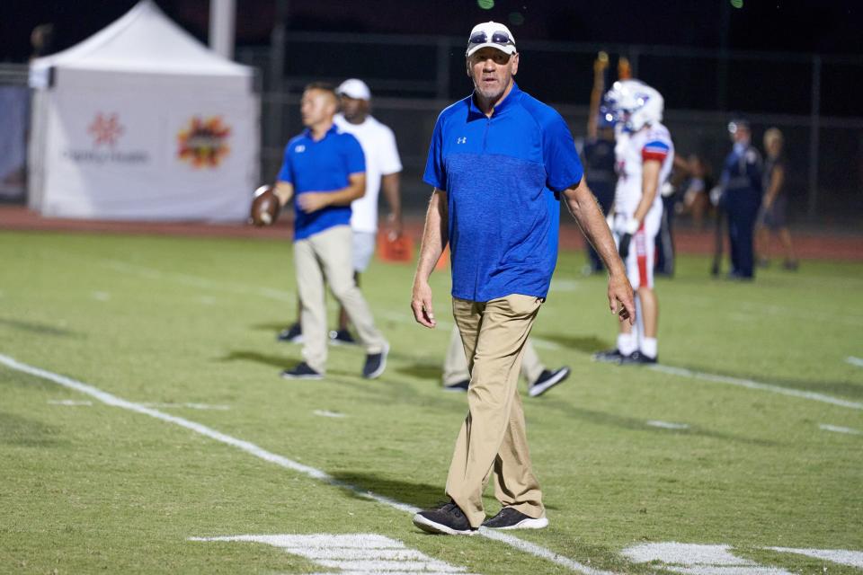 Dave Logan, the head football coach of Cherry Creek High School, watches his team warm up on Friday, Sept. 10, 2021 at the Chandler High School football field in Chandler, Ariz.