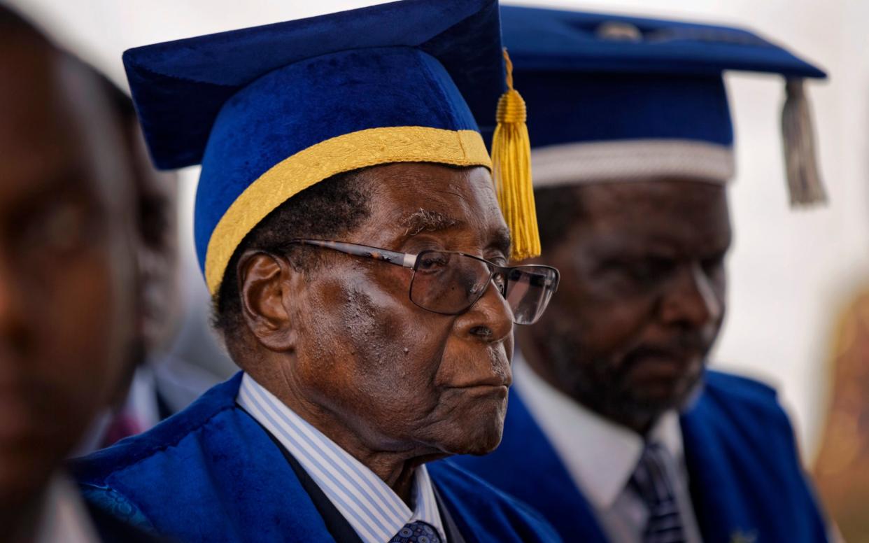 Robert Mugabe, seen today at a university graduation, is being urged to resign - AP