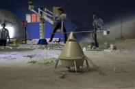 In this photo taken Sunday, Dec. 15, 2013, a girl uses a mechanical arm that allows her to experience what low gravity on the moon will feel like, near a model depicting a Chinese space craft landing on the moon, at the China Science and Technology Museum in Beijing. China's Nov. 24, 2020, trip to the moon and, presumably, back is the latest milestone in the Asian powerhouse's slow but steady ascent to the stars. (AP Photo/Ng Han Guan, File)