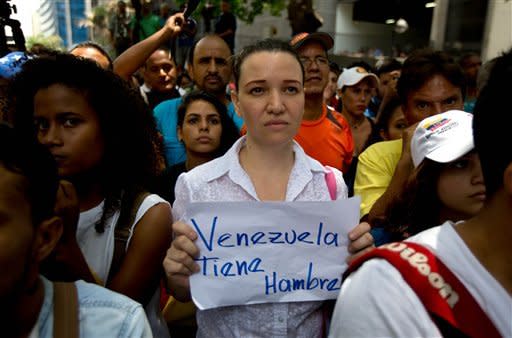 An opposition members holds a handwritten message that that reads in Spanish;