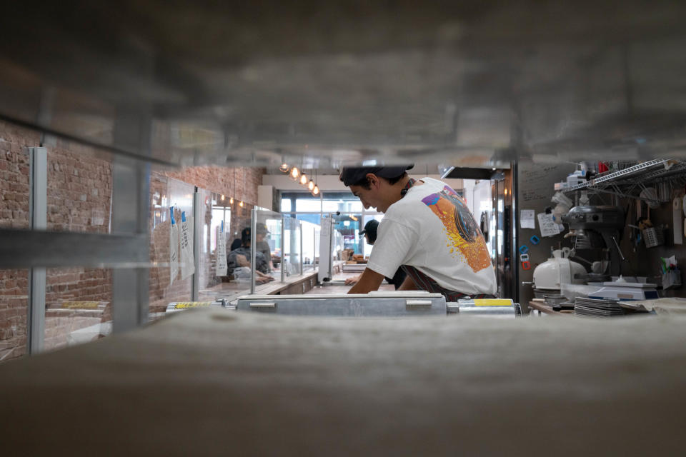 Alex Cavolo folds butter into dough, April 7, 2022, at Proof Bread, 125 W. Main Street, Mesa, Arizona.