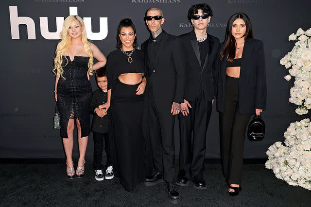 <p>Frazer Harrison/Getty</p> Kourtney Kardashian and Travis Barker posing with their kids at the premiere of 'The Kardashians' in April 2022