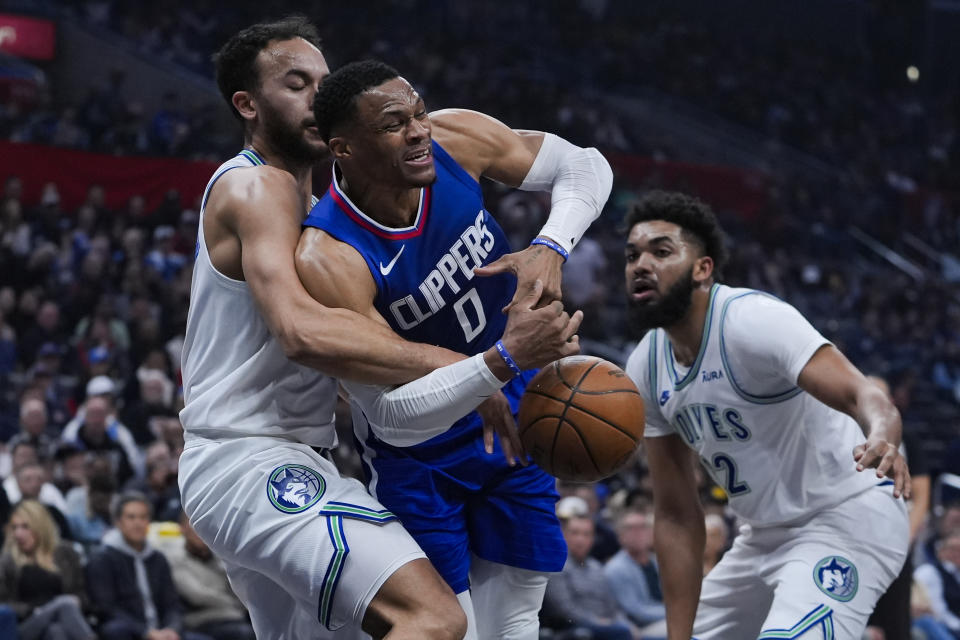 Los Angeles Clippers guard Russell Westbrook, center, attempts to drive past Minnesota Timberwolves forward Kyle Anderson, left, and center Karl-Anthony Towns during the first half of an NBA basketball game, Monday, Feb. 12, 2024, in Los Angeles. (AP Photo/Ryan Sun)