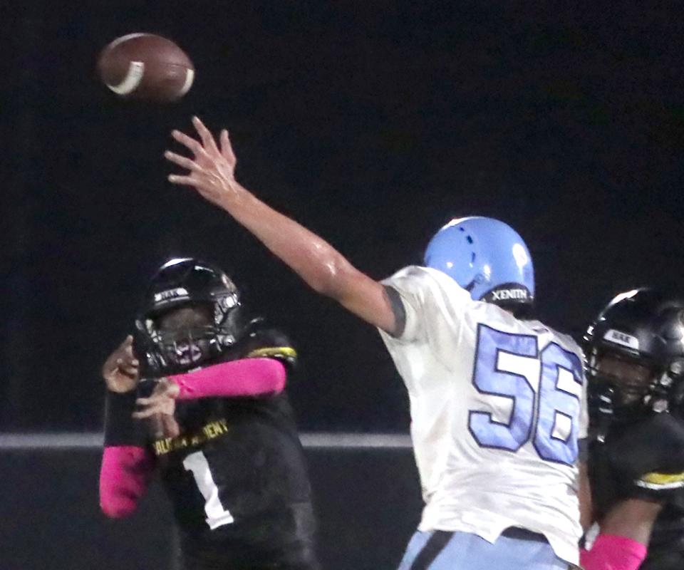 Halifax Academy's QB Karl Nelson #1 gets a pass off, Friday October 13, 2023 under heavy pressure from Jordan Christian Prep's Travis Harrison #56.