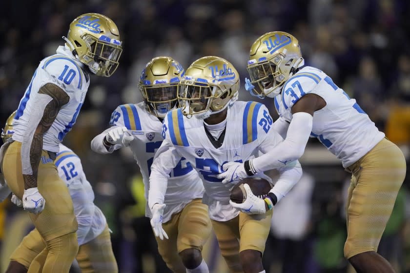 UCLA defensive back Devin Kirkwood (26) celebrates with Ale Kaho (10), Obi Eboh (22) and Quentin Lake (37)