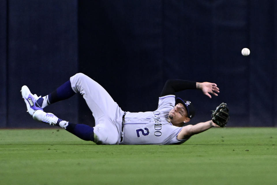 Colorado Rockies center fielder Yonathan Daza dives but the ball bounces over him on a double by San Diego Padres' Ha-Seong Kim during the fifth inning of a baseball game in San Diego, Friday, March 31, 2023. (AP Photo/Alex Gallardo)