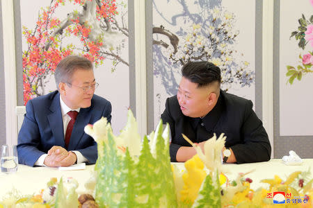 South Korean President Moon Jae-in speaks to North Korean leader Kim Jong Un during a luncheon, in this photo released by North Korea's Korean Central News Agency (KCNA) on September 21, 2018. KCNA via REUTERS