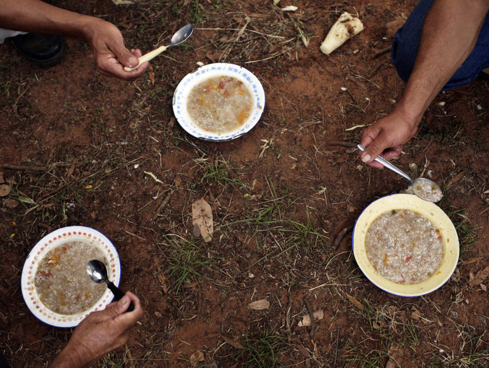 FILE - In this March 24, 2011 file photo, members of the National Farmers Federation (FNC) eat soup for breakfast after protesting to demand government land reform in Asuncion, Paraguay. The roots of Paraguay's land crisis stretch back 140 years, through a seemingly intractable pattern that keeps about 1 percent of the population in control of 77 percent of arable land while 31 percent of Paraguayans live in extreme poverty, according to the United Nations. (AP Photo/Jorge Saenz, File)