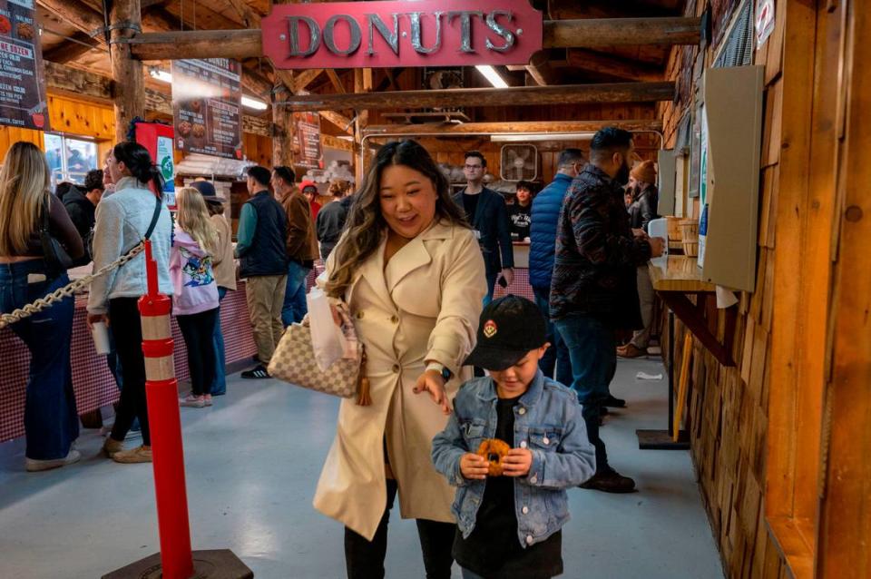 Liz Khang of Sacramento buys apple donuts with her nephew Xai Yanez, 4, while visiting High Hill Ranch on Saturday.