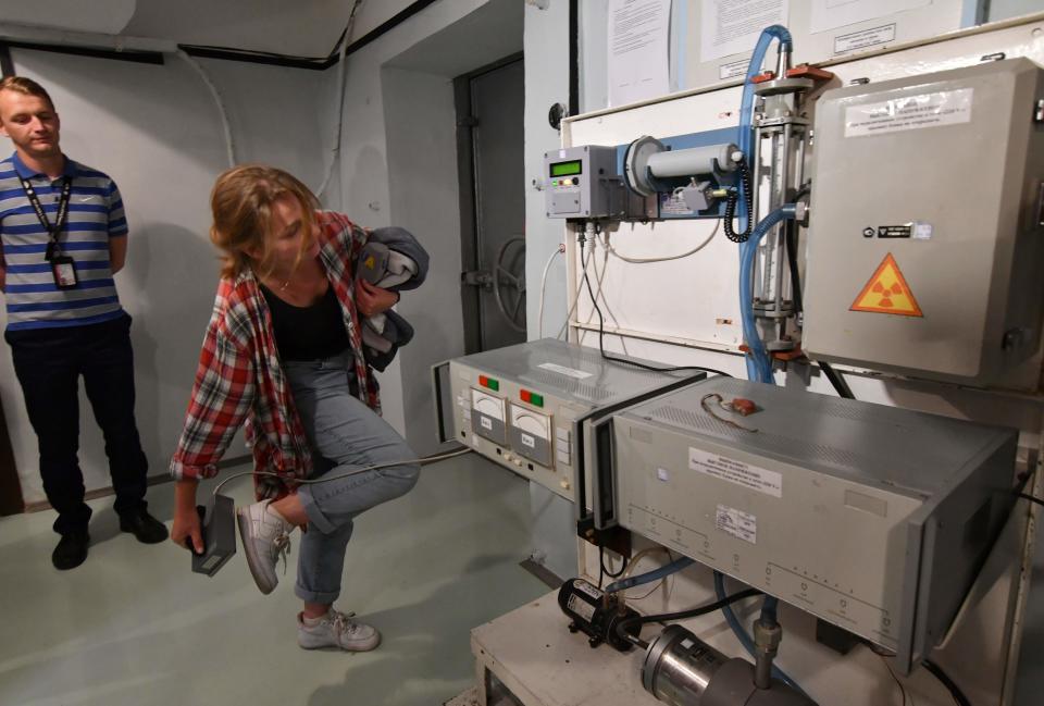 A visitor check her shoes with geiger counter during a tour of the underground shelter of Chernobyl nuclear power plant on June 7, 2019. A geiger counter is a device used to measure radiation. The underground shelter held the first meetings of the official commission that handled the subsequences of the disaster in April 1986.