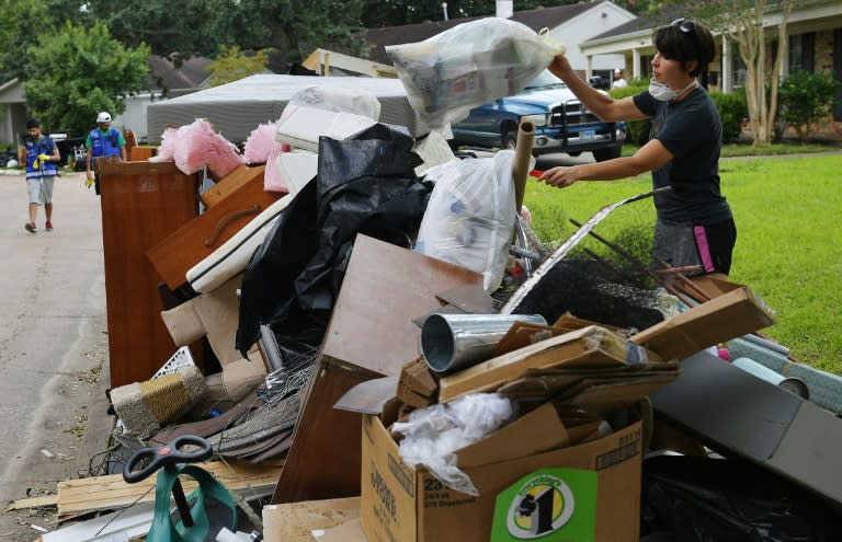 Kelsey Johnson tosses away a bag of flood-damaged belongings in front of her home in the Westbury neighborhood of southwest Houston