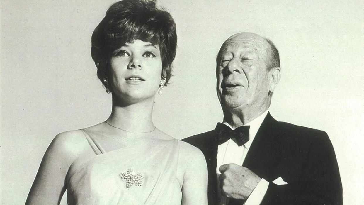 Jane Lahr wearing a white dress next to her father in a tux.