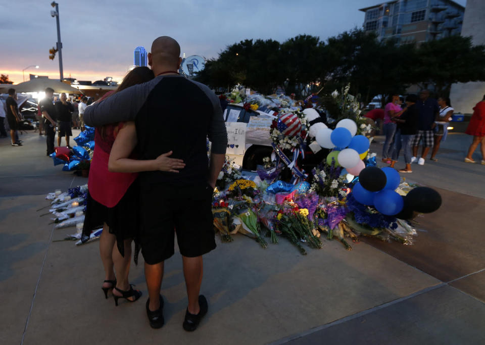 Alex Pacheco and Holly Caperton visit a makeshift memorial in honor of the slain Dallas police officers in front of police headquarters