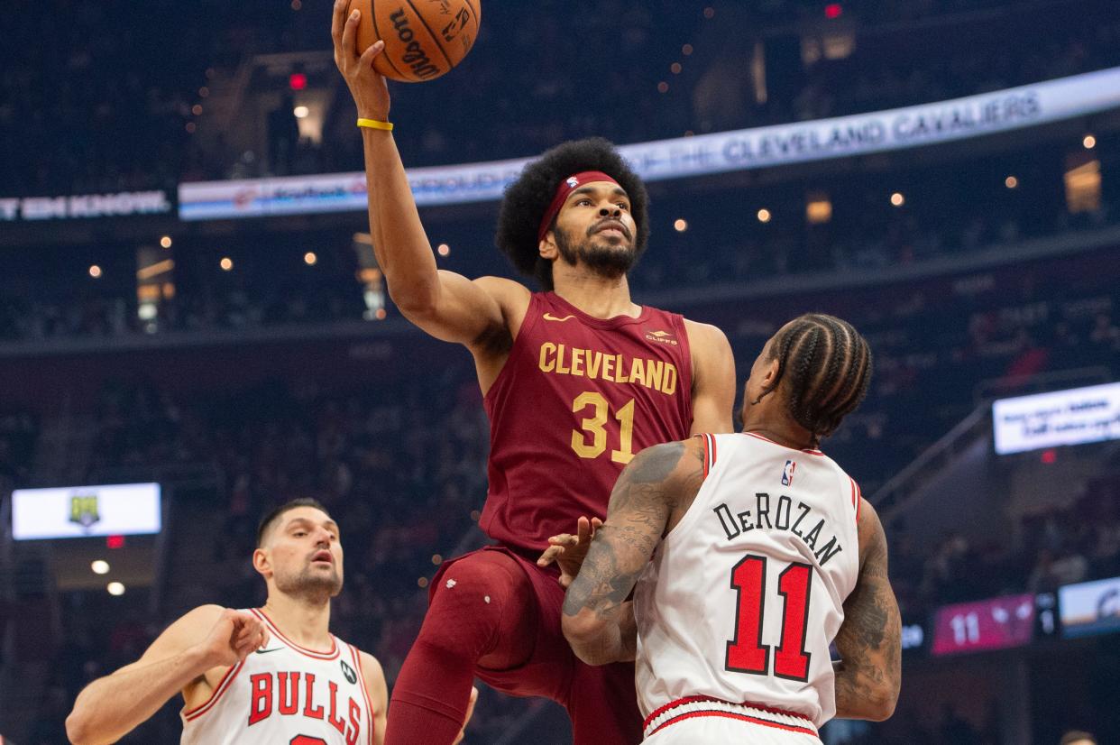 Cleveland Cavaliers' Jarrett Allen (31) drives to the basket as Chicago Bulls' DeMar DeRozan (11) defends and Nikola Vucevic watches during the first half of an NBA basketball game Wednesday, Feb. 14, 2024, in Cleveland. (AP Photo/Phil Long)