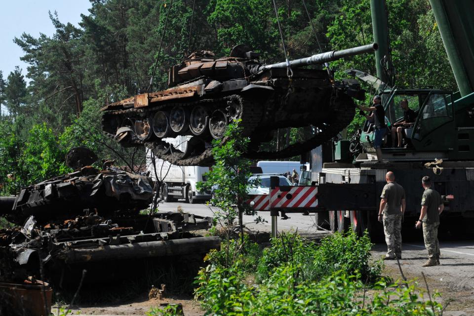 Ukrainian servicemen collect destroyed Russian tanks outside the village of Dmytrivka, in Kyiv region (AFP via Getty Images)