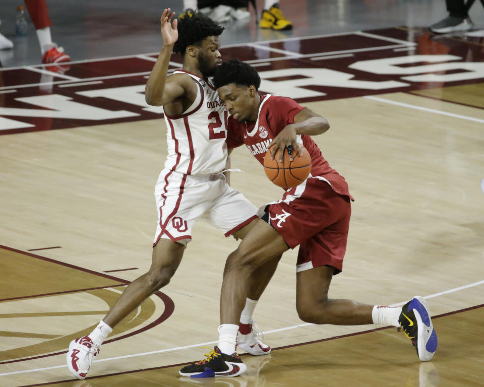 Alabama's Herbert Jones (1) goes against Oklahoma's Elijah Harkless (24) during the second half of an NCAA college basketball game in Norman, Okla., Saturday, Jan. 30, 2021. (AP Photo/Garett Fisbeck)