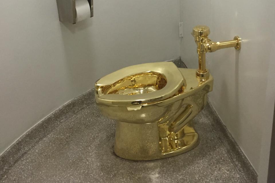 In this file photo taken on Sept. 15, 2016, a fully functioning solid gold toilet, made by Italian artist Maurizio Cattelan, went into public use at the Guggenheim Museum in New York. Thieves stole the 18-karat gold toilet from an exhibition of artworks at Britain's Blenheim Palace, police said Saturday, causing significant flooding.