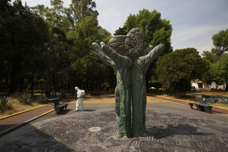 A municipal employee, wearing protective gear, disinfect an area of a Coyoacan public park as a preventive measure against the spread of the new coronavirus, in Mexico City, Saturday, April 4, 2020. Mexico has started taking tougher measures against the new coronavirus, but some experts warn the country is acting too late and testing too little to prevent the type of crisis unfolding across the border in the United States. (AP Photo/Fernando Llano)