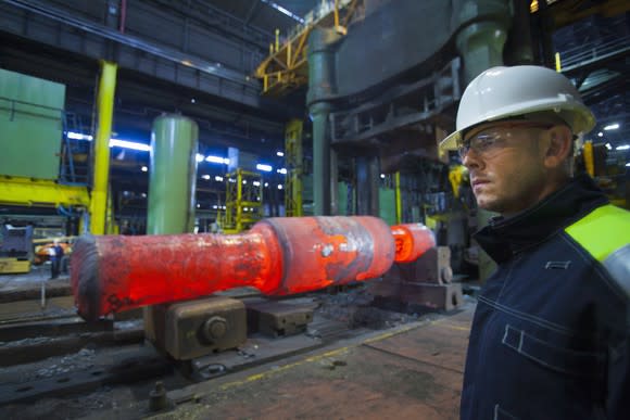 A worker standing in front of red hot steel