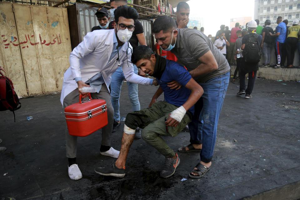 An injured protester is rushed to a hospital during clashes between Iraqi security forces and anti-government protesters in Baghdad, Iraq, Monday, Nov. 11, 2019. (AP Photo/Hadi Mizban)