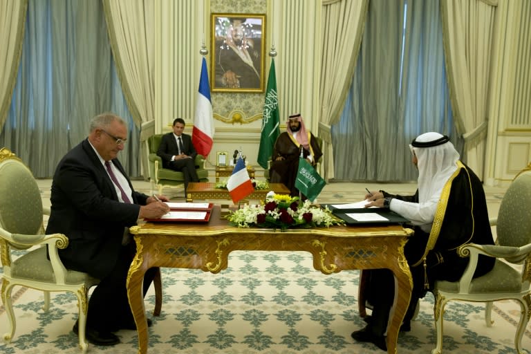 French military shipbuilder DCNS' CEO Herve Guillou (L) signs agreements as French Prime Minister Manuel Valls (2L) and Saudi Defence Minister Mohammed bin Salman bin Abdul Aziz (2R) look on in Riyadh on October 13, 2015