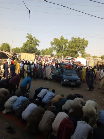 People are seen praying as others fleeing the town of Baga arrive to Maiduguri, Nigeria, December 29, 2018. REUTERS/Ahmed Kinngimi