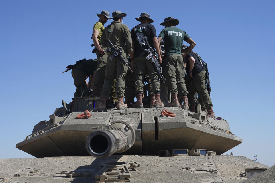 Israeli soldiers work on armored military vehicles at a staging ground near the Israeli-Gaza border, in southern Israel, Wednesday, May 8, 2024. (AP Photo/Tsafrir Abayov)