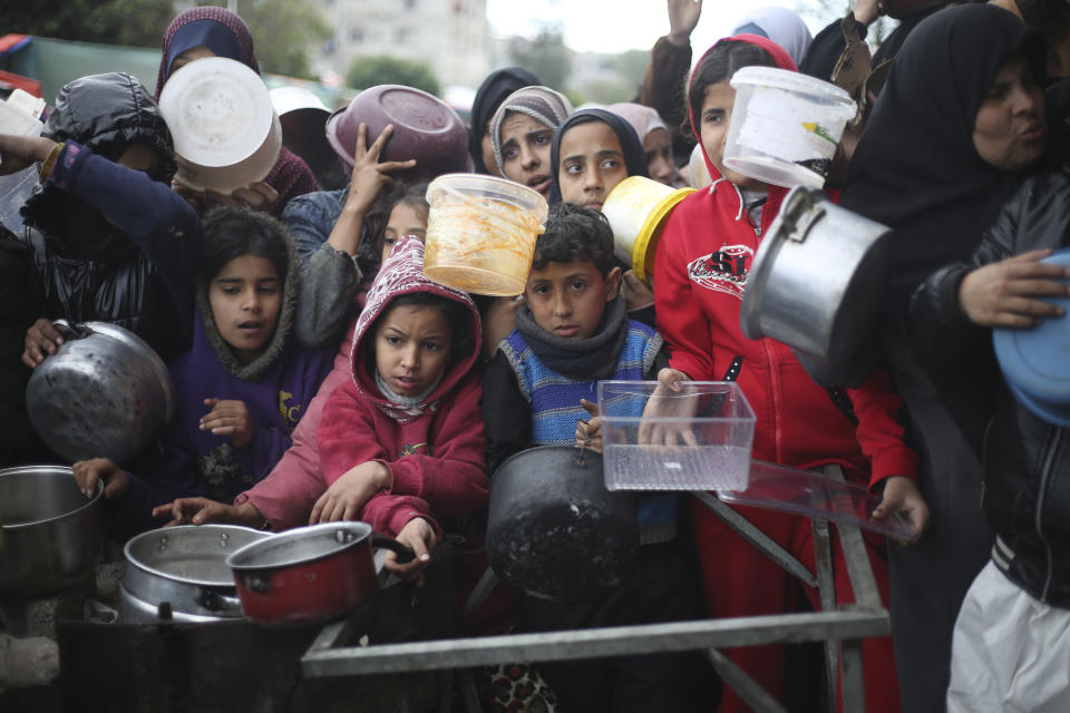 Palestinians line up for free food distribution during the ongoing Israeli air and ground offensive in Khan Younis, Gaza Strip, Friday, Feb. 2, 2024. (AP Photo/Hatem Ali)