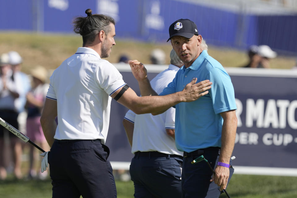 Former Ukrainian international soccer player Andriy Shevchenko, right, taps hand with former Welch international soccer player Gareth Bale during an all stars golf match between Team Colin Montgomerie and Team Cory Pavin at the Marco Simone Golf Club in Guidonia Montecelio, Italy, Wednesday, Sept. 27, 2023. The Ryder Cup starts Sept. 29, at the Marco Simone Golf Club. (AP Photo/Alessandra Tarantino)