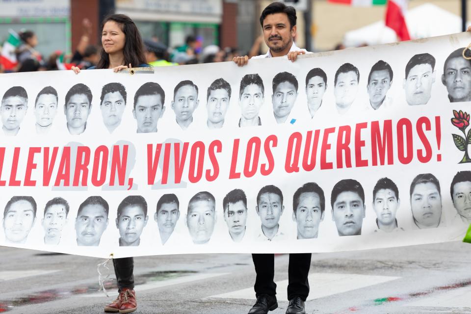 Chicago, Illinois, Estados Unidos. Septiembre 8, 2019. Un hombre y una mujer sostienen una pancarta con fotos de estudiantes desaparecidos México. (Shutterstock / Roberto Galan)