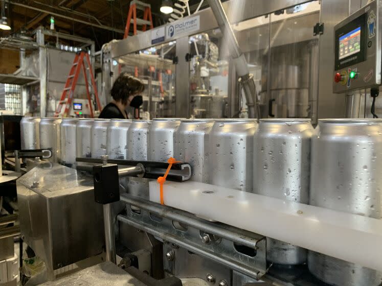 Aluminum cans make their way down the canning line at Almanac Beer Co. in Alameda, California.